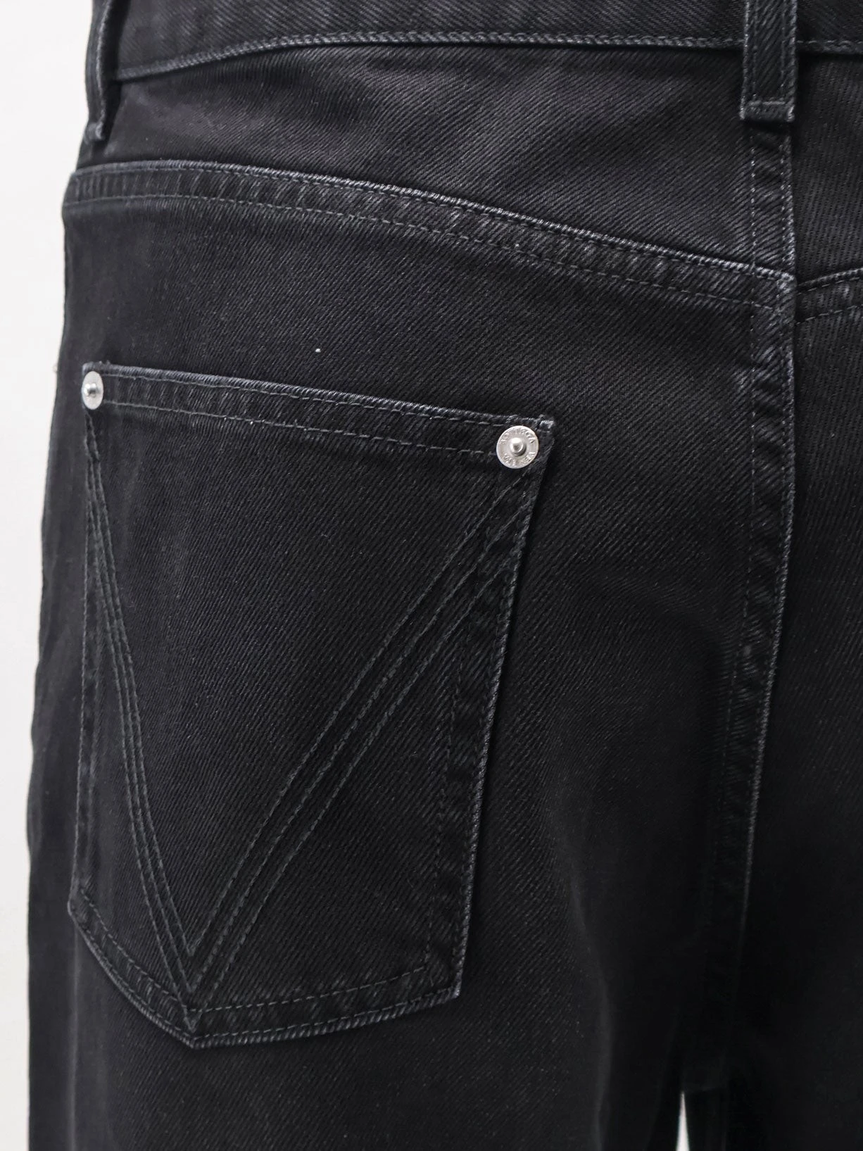 Black denim trousers with back leather patch.webp