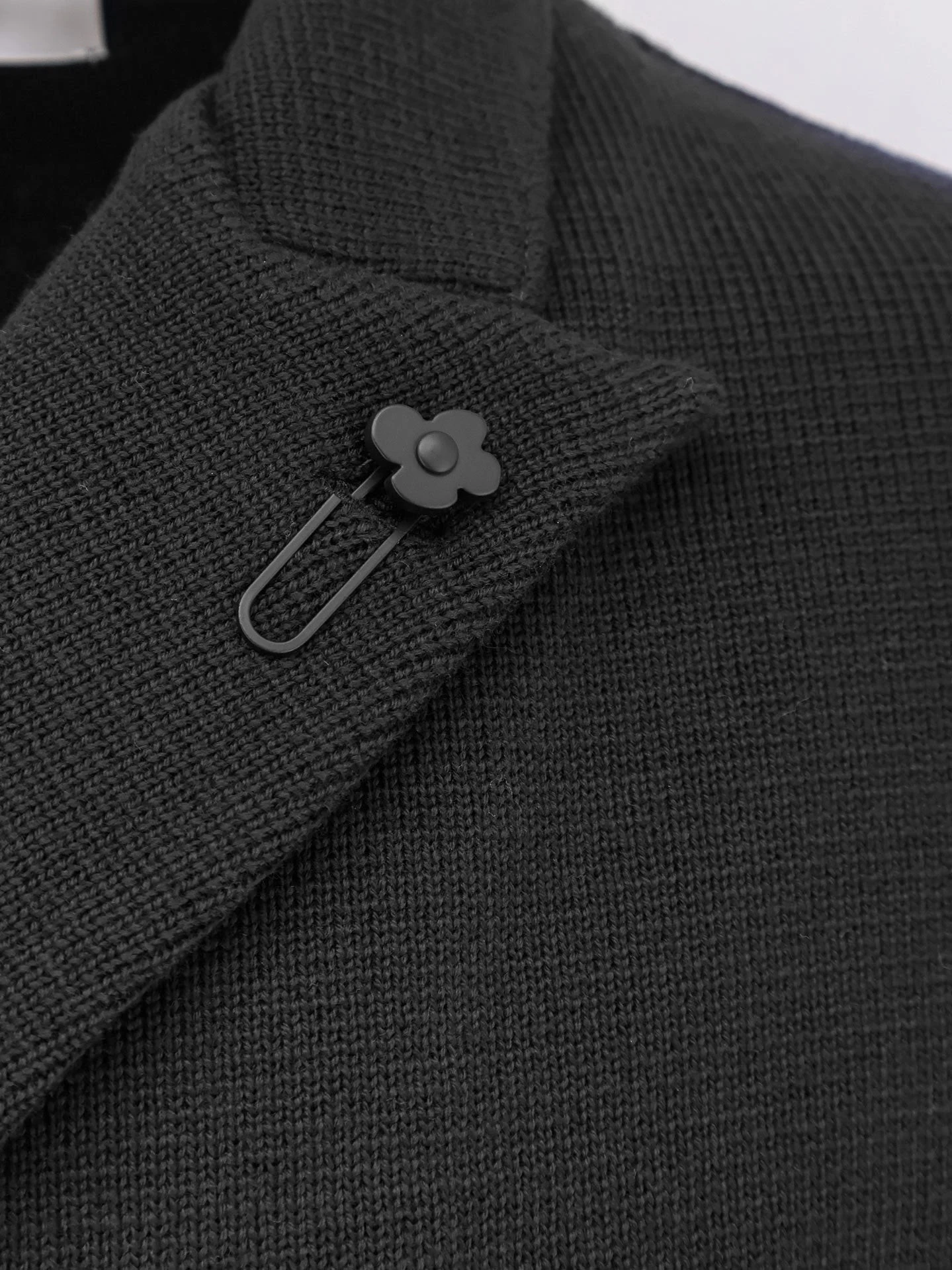 Knitted blazer with iconic brooch.webp