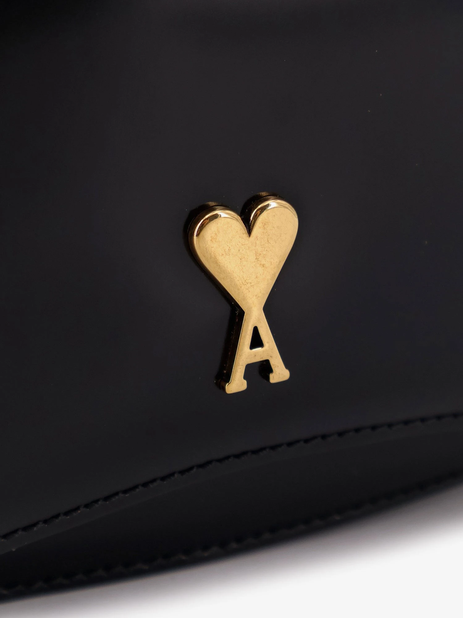 Leather shoulder bag with metal logo on the front.webp