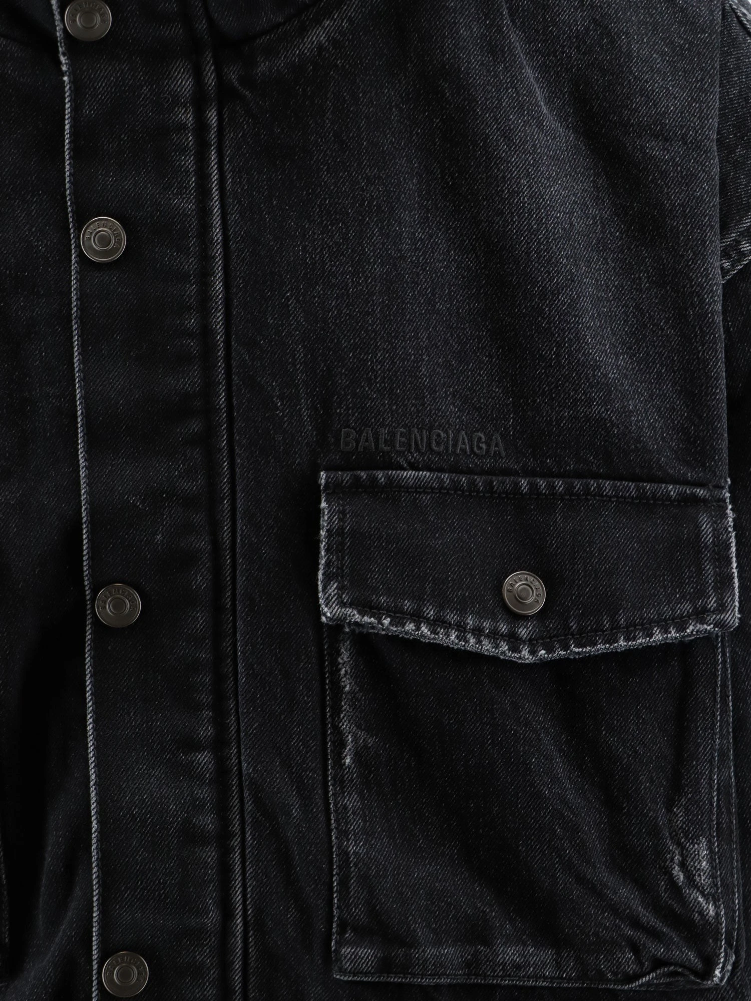 Black denim jacket with embroidered logo on the front.webp