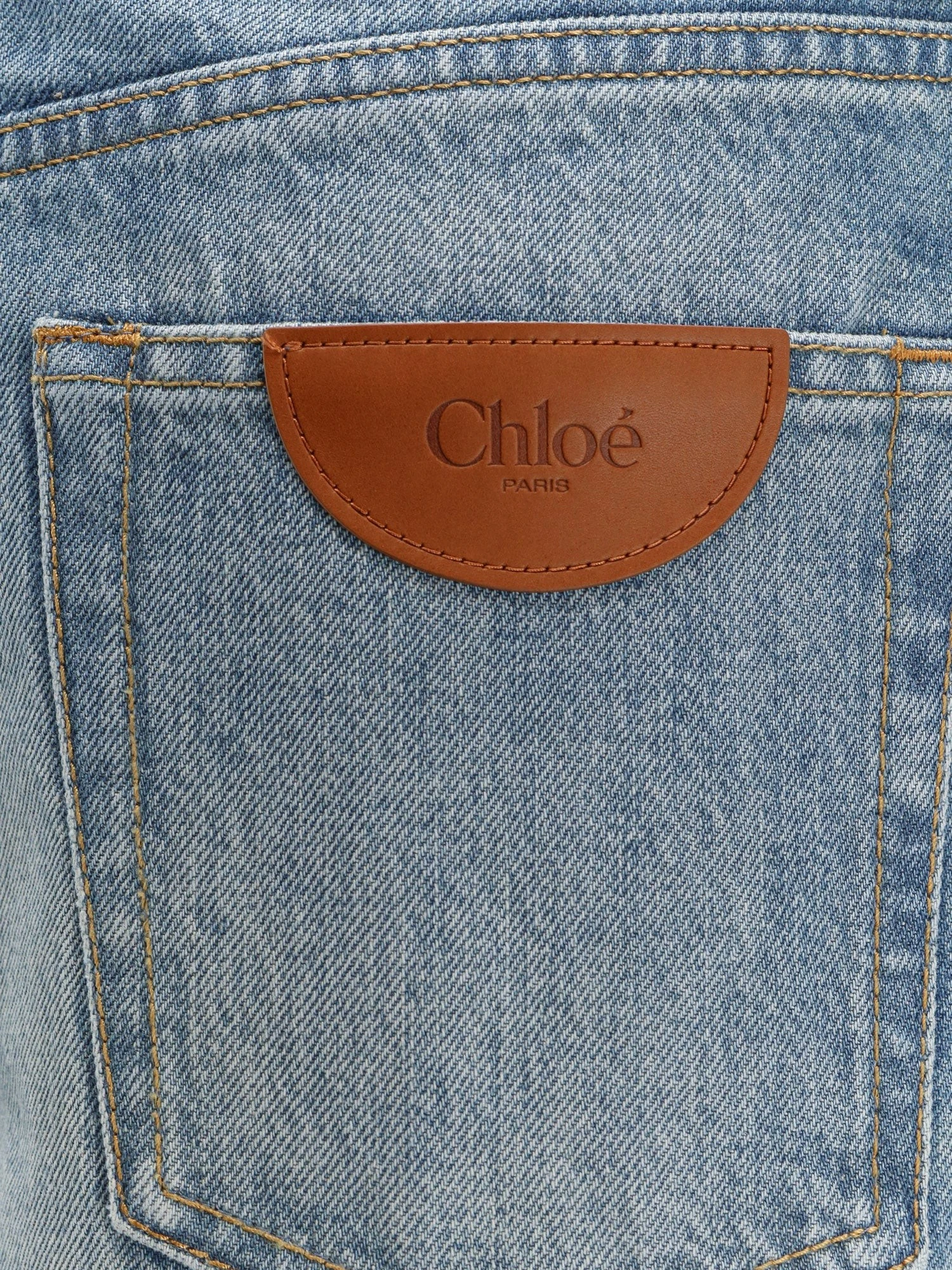 Blue denim jeans with logo label on the back.webp